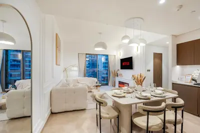 a kitchen and living room with a table and chairs at Stunning 2BR Burj Khalifa View from Infinity Pool Grande Signature Residences in Dubai