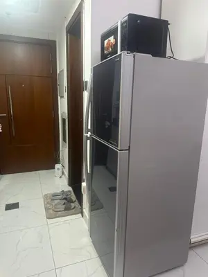 a refrigerator with a microwave on top of it at Twin tower in Dubai
