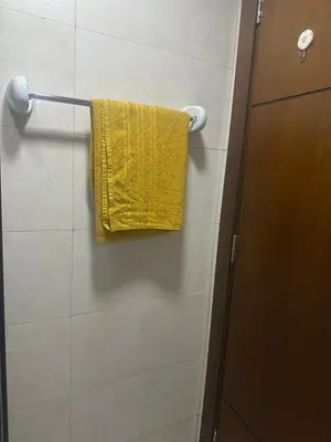 a yellow towel hanging on a towel rack in a bathroom at Twin tower in Dubai