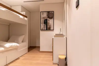 a small bedroom with a bed and a small refrigerator at 1BR Plus Studio Apartment With Burj View In Downtown Dubai in Dubai
