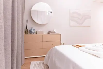 a bedroom with a dresser and a mirror at 1BR Plus Studio Apartment With Burj View In Downtown Dubai in Dubai