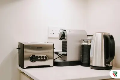 a kitchen counter with a toaster and a coffee maker at 2BR Apartment With Lagoon Access In Creek Harbour in Dubai