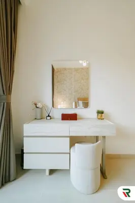 a white dressing table with a mirror and a stool at 2BR Apartment With Lagoon Access In Creek Harbour in Dubai