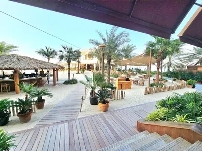 a resort with palm trees and a deck with plants at Beachfront-Huge Apt-in Palm-Private Beach in Dubai