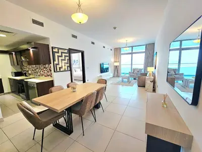 a dining room and living room with a table and chairs at Beachfront-Huge Apt-in Palm-Private Beach in Dubai