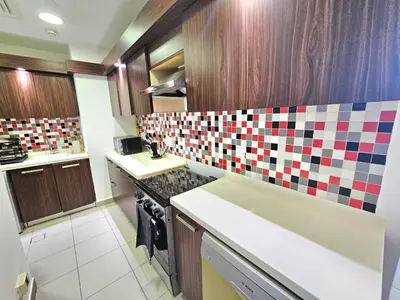 a kitchen with a colorful tile backsplash at Beachfront-Huge Apt-in Palm-Private Beach in Dubai