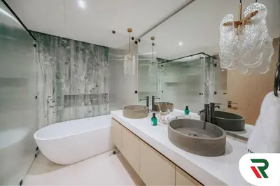 a bathroom with two sinks and a tub and a bath tub at 4 Bedroom Burj View Apartment In Downtown Dubai in Dubai