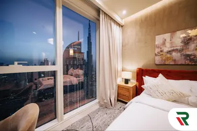 a bedroom with a large window with a city view at 4 Bedroom Burj View Apartment In Downtown Dubai in Dubai