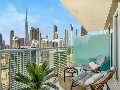 a balcony with two chairs and a view of the city at Chic 1BR With Burj Views And Near Dubai Mall in Dubai
