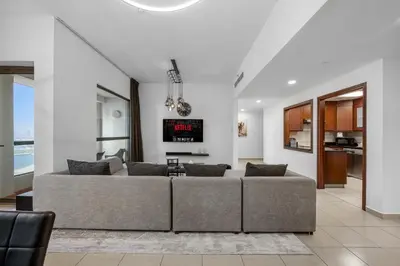 a living room with a couch and a tv at Beachfront JBR Stunning Views, Pool & Gym in Dubai