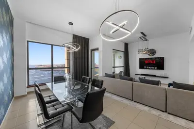 a living room with a glass table and a couch at Beachfront JBR Stunning Views, Pool & Gym in Dubai
