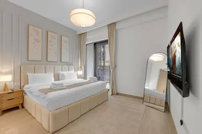 a bedroom with a large bed and a flat screen tv at Creek Beach Getaway Lagoon, Pool & Gym Access in Dubai