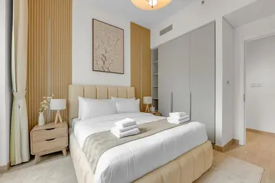 a white bedroom with a large bed with white pillows at Creek Beach Getaway Lagoon, Pool & Gym Access in Dubai