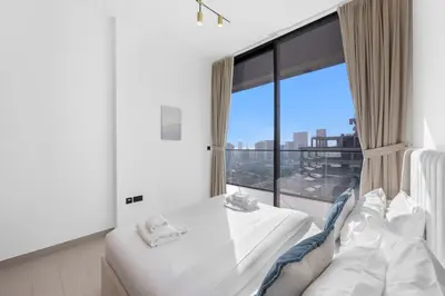 a hotel room with a bed and a large window at Luxurious JVC Getaway Infinity Pool & Gym in Dubai