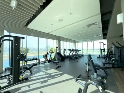 a gym with treadmills and ellipticals in a building at Urban Haven Pool, Gym & Spectacular Views in Dubai
