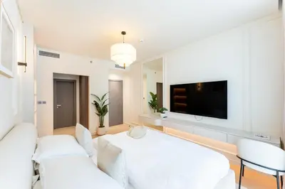 a living room with white furniture and a flat screen tv at Urban Haven Pool, Gym & Spectacular Views in Dubai