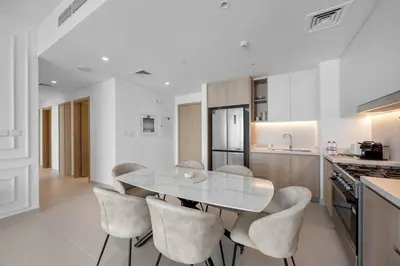a kitchen with a table and chairs in a kitchen at Burj Khalifa Views Luxury Stay with Pool & Gym in Dubai