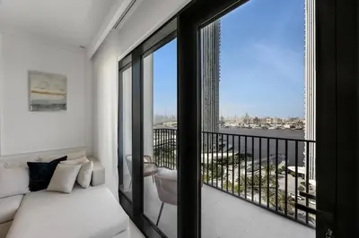 a bedroom with a balcony with a view of the water at Burj Khalifa Views Luxury Stay with Pool & Gym in Dubai