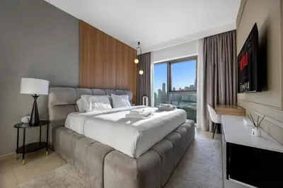 a bedroom with a large bed and a couch at Burj Khalifa Views Pool, Gym & Downtown Ease in Dubai
