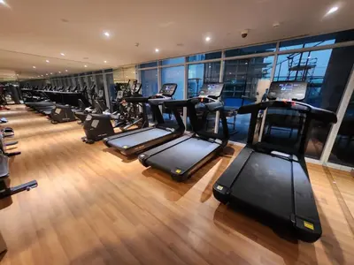 a gym with a row of treadmills at 21 Studio in Skyz by Danube, Arjan in Dubai