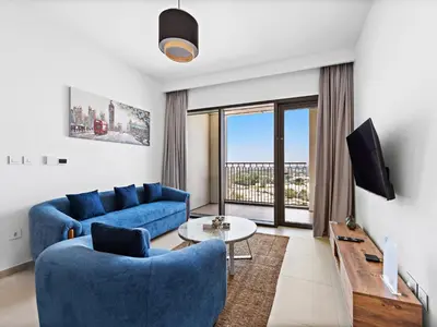 a living room with a blue couch and a tv at Chic & Classic 1BDR In Downtown Views-14 in Dubai