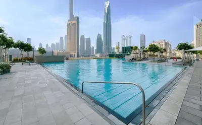 a large swimming pool with a city skyline in the background at Chic & Classic 1BDR In Downtown Views-14 in Dubai