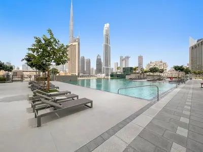 a swimming pool with benches and a city skyline at Chic & Classic 1BDR In Downtown Views-14 in Dubai