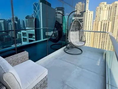 a balcony with a chair and a view of a city at Luxury 2 Bedroom Shemara Tower Dubai Marina in Dubai