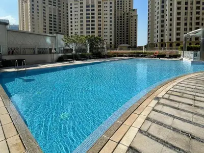 a large blue swimming pool in a city with tall buildings at Luxury 2 Bedroom Shemara Tower Dubai Marina in Dubai