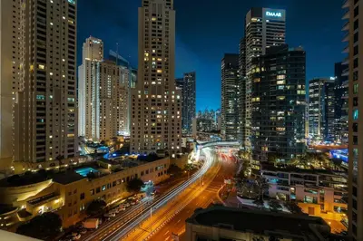 a city skyline at night with traffic on the street at FIRST CLASS 1BR Luxury Marina View Escape in Dubai