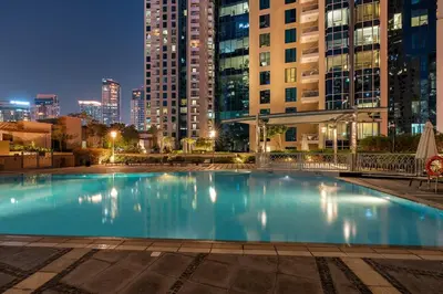 a large swimming pool in a city at night at FIRST CLASS 1BR Luxury Marina View Escape in Dubai