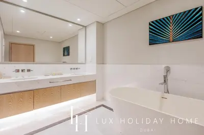 a bathroom with a tub and a sink and a mirror at LUX Iconic Views at The Palm Tower Suite 8 in Dubai