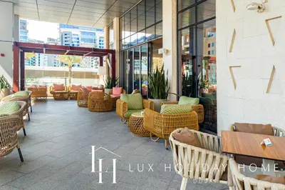 a restaurant with wicker chairs and tables in a building at LUX Iconic Views at The Palm Tower Suite 8 in Dubai
