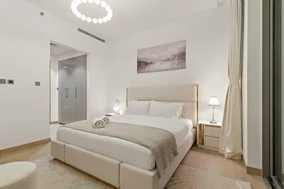 a white bedroom with a large bed and a mirror at FIRST CLASS 1BR Luxe Hideaway Escape in Dubai