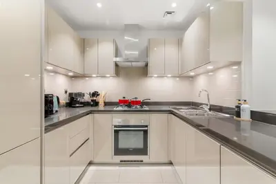 a large kitchen with white cabinets and appliances at FIRST CLASS 1BR Luxe Hideaway Escape in Dubai