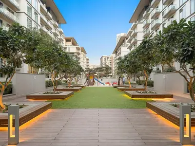 a courtyard in a building with trees and a playground at FIRST CLASS 1BR Luxe Hideaway Escape in Dubai