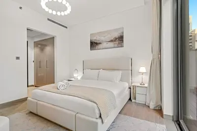 a white bedroom with a large bed and a window at FIRST CLASS 1BR Luxe Hideaway Escape in Dubai