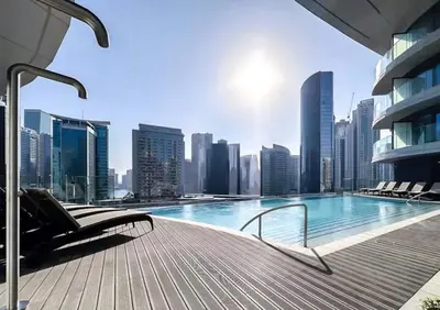 a swimming pool with chairs and a city skyline at have fun with your family and friends in our apt in Dubai