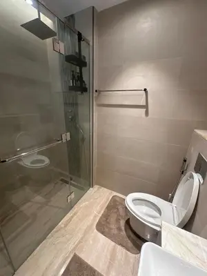 a bathroom with a toilet and a glass shower at have fun with your family and friends in our apt in Dubai