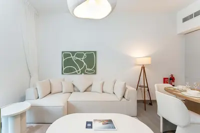 a living room with a white couch and a table at PVH - Kensington Waters - Lavish 1BR - Park Front in Dubai