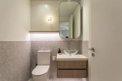 a bathroom with a sink and a toilet and a mirror at PVH - Kensington Waters - Lavish 1BR - Park Front in Dubai