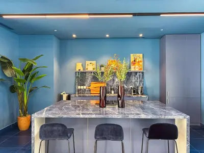 a room with a marble counter with chairs and paintings at PVH - Kensington Waters - Lavish 1BR - Park Front in Dubai