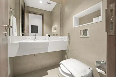 a bathroom with a white sink and a toilet at FIRST CLASS 1BR Relaxing Urban Escape in Dubai