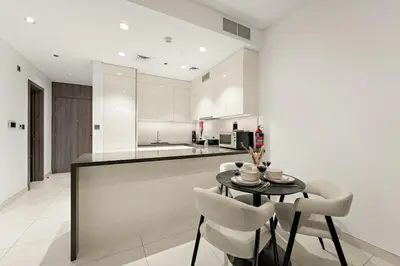a kitchen with a table and chairs in a room at FIRST CLASS 1BR Relaxing Urban Escape in Dubai