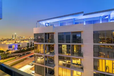 a tall white building with a city at night at FIRST CLASS 1BR Relaxing Urban Escape in Dubai