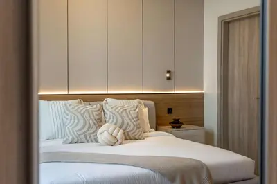 a bedroom with a bed with white pillows and cabinets at Luxury 2BR w City View Balcony in Dubai