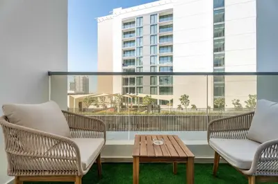 a balcony with chairs and a table and a building at Luxury 2BR w City View Balcony in Dubai