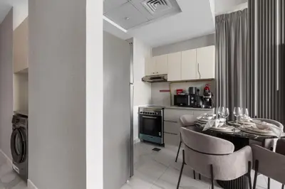 a kitchen with a table and chairs in a kitchen at Gogoto6 2BR Super Premium Canal & Burj Khalifa View in Dubai