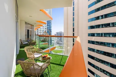 a balcony with chairs and a table on a building at Gogoto6 2BR Super Premium Canal & Burj Khalifa View in Dubai