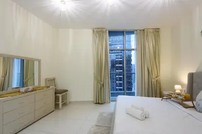 a white bedroom with a bed and a large window at Prime Located 3B with full Marina Views, Near Beach & Marina Mall in Dubai